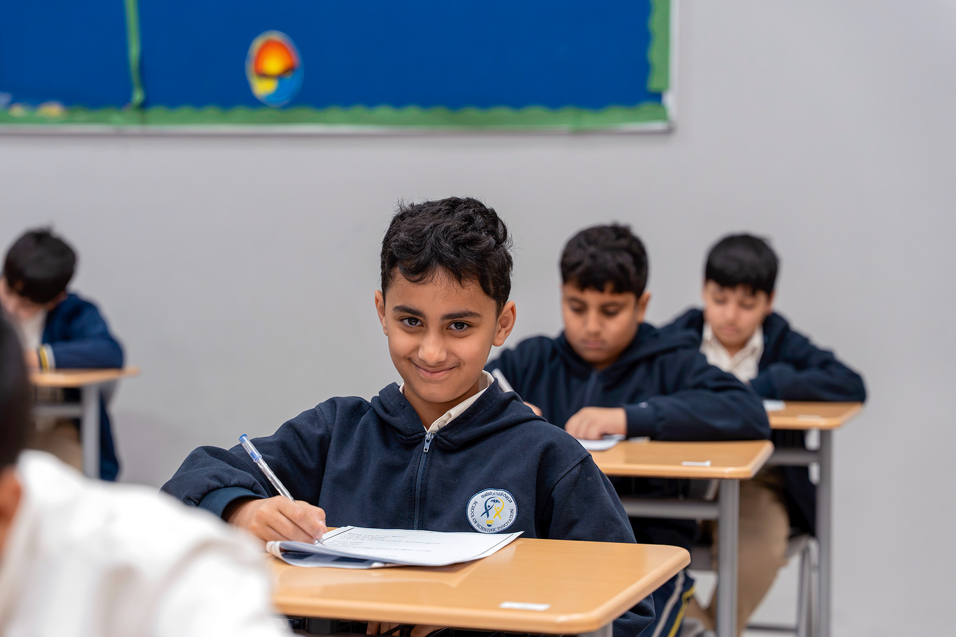 Young girl pointing at an interactive screen in her classroom